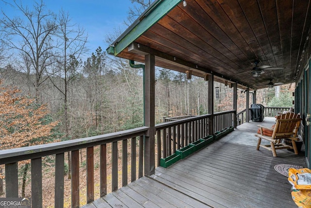 wooden terrace with ceiling fan and a grill