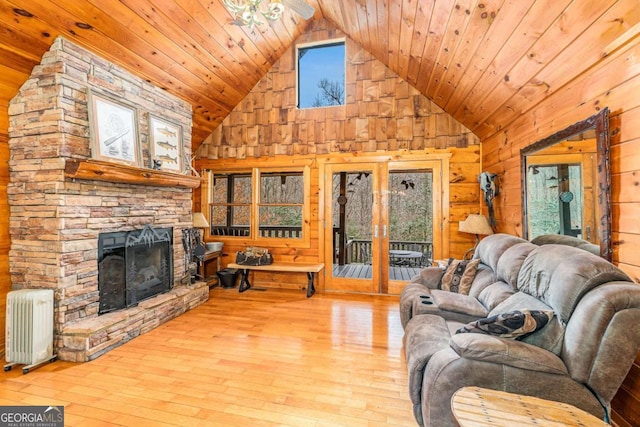 living room featuring radiator, a fireplace, light wood-type flooring, and wood ceiling