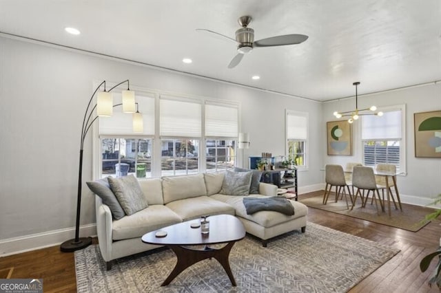 living room featuring ceiling fan with notable chandelier and hardwood / wood-style flooring