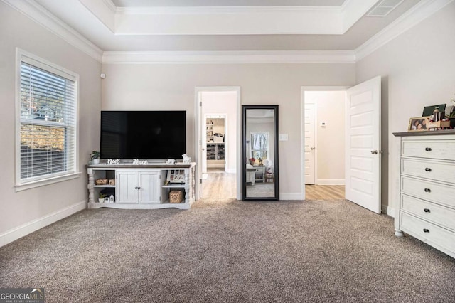 unfurnished living room featuring ornamental molding, a tray ceiling, and carpet flooring