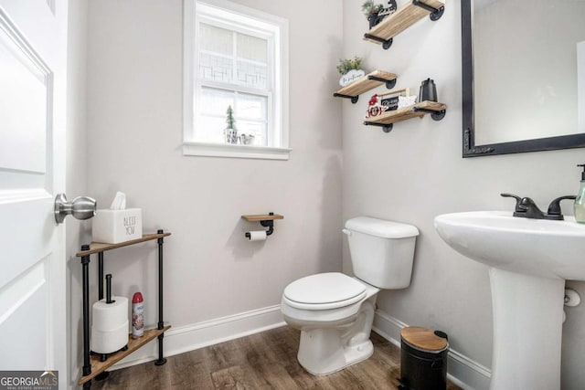 bathroom with toilet, wood-type flooring, and sink