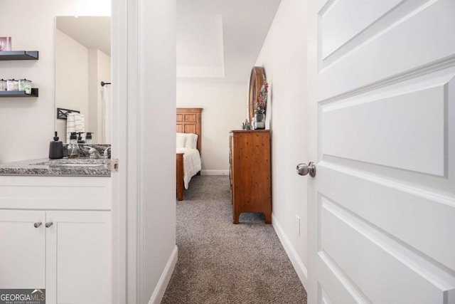 corridor with carpet floors and sink