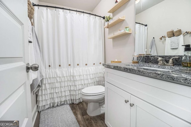 bathroom with toilet, vanity, and hardwood / wood-style flooring