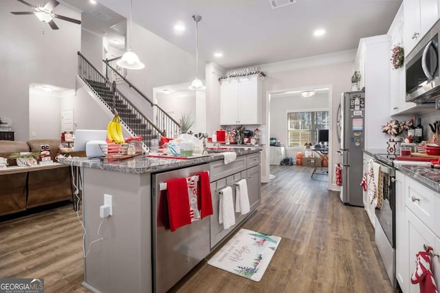 kitchen with white cabinets, hanging light fixtures, and appliances with stainless steel finishes