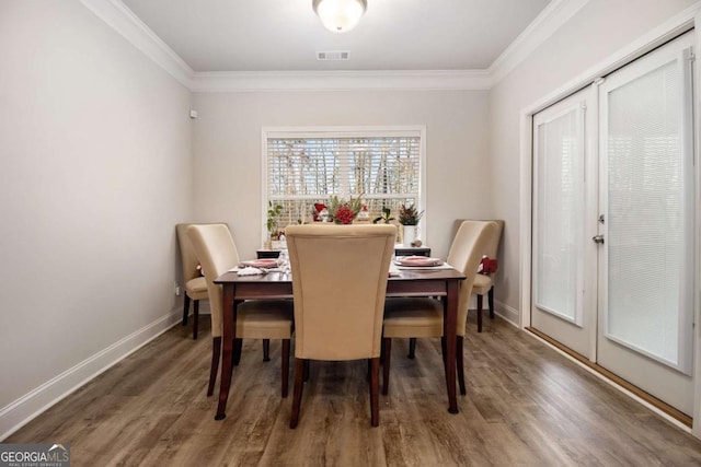 dining room with ornamental molding, dark hardwood / wood-style flooring, and french doors