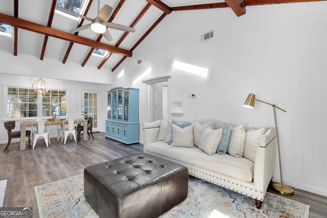 living room featuring beam ceiling, high vaulted ceiling, ceiling fan with notable chandelier, and hardwood / wood-style flooring