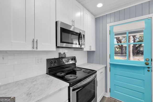 kitchen featuring white cabinetry, tasteful backsplash, light stone counters, and appliances with stainless steel finishes