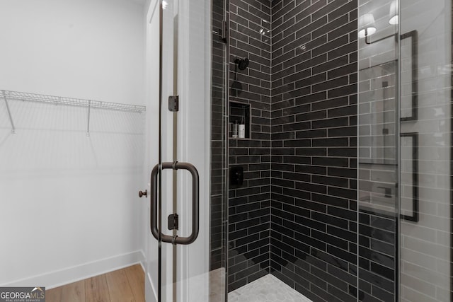 bathroom featuring walk in shower and hardwood / wood-style flooring