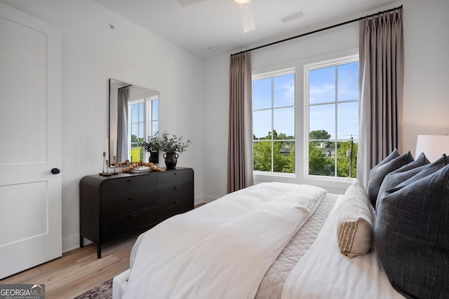 bedroom featuring multiple windows, ceiling fan, and light hardwood / wood-style floors