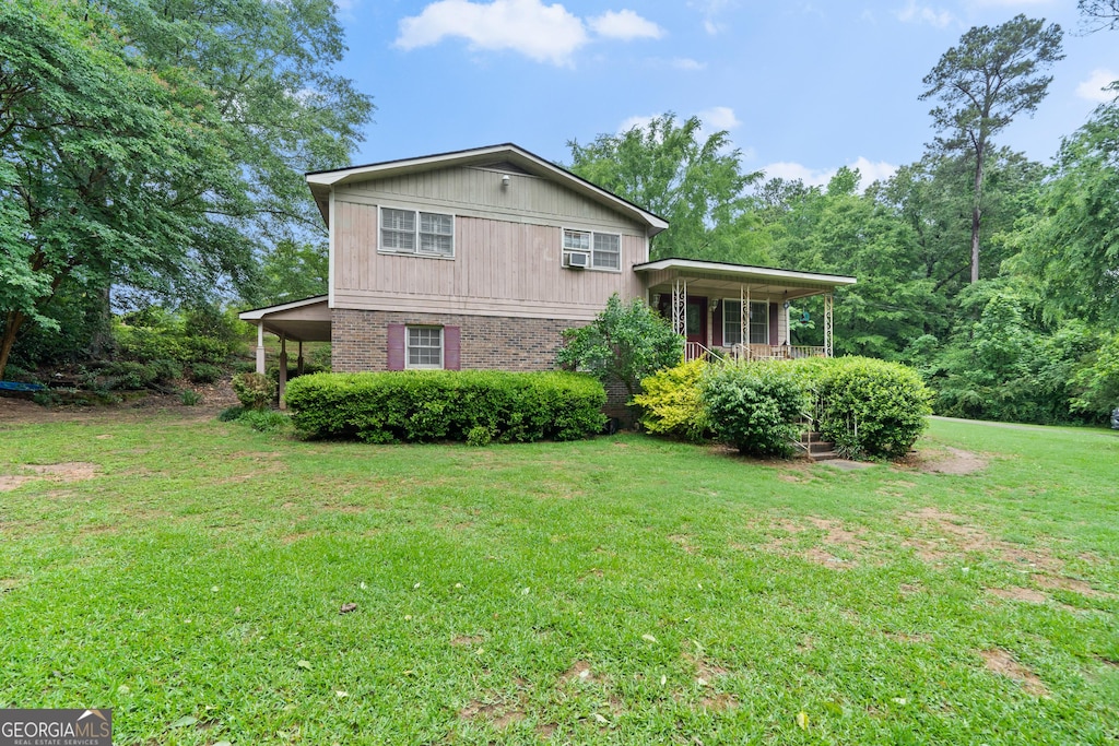 view of side of home with a porch and a lawn