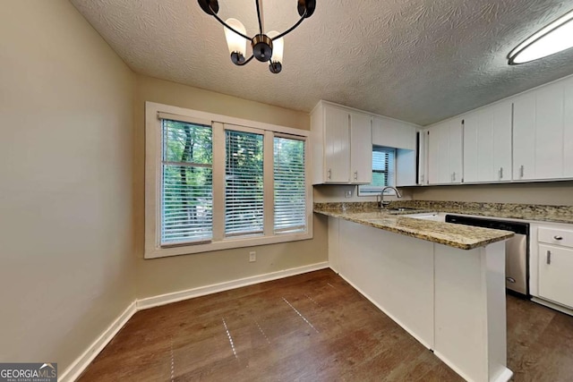 kitchen featuring sink, white cabinetry, dishwasher, hanging light fixtures, and light stone countertops