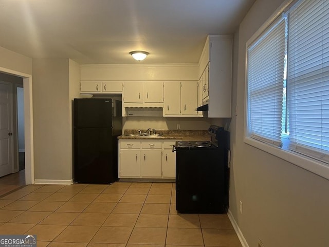 kitchen with black appliances, white cabinetry, light tile patterned flooring, and sink