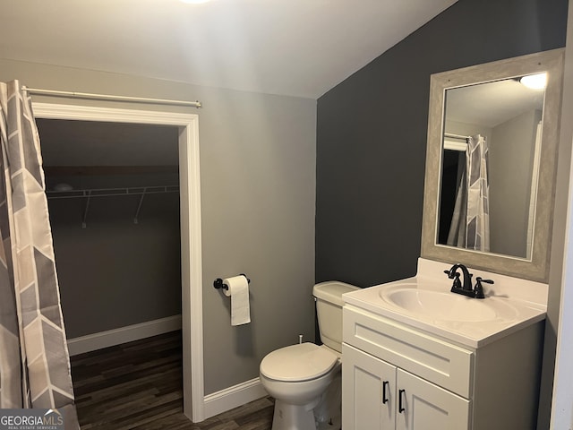 bathroom featuring toilet, lofted ceiling, vanity, and hardwood / wood-style flooring