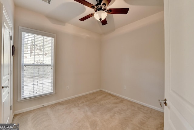 carpeted spare room featuring ceiling fan