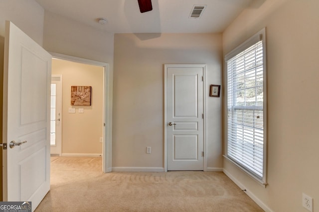 unfurnished bedroom featuring ceiling fan and light carpet