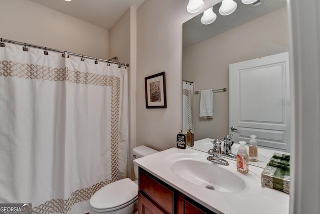 bathroom with toilet, vanity, and curtained shower