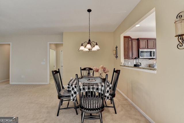 carpeted dining space with an inviting chandelier