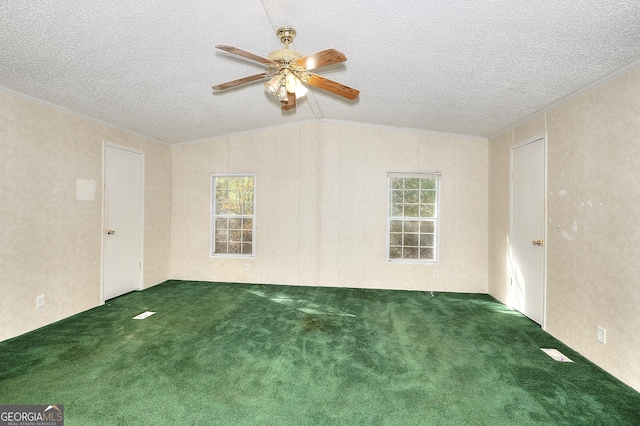 empty room with ornamental molding, a textured ceiling, dark colored carpet, and vaulted ceiling