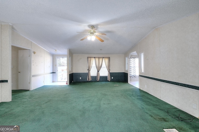 unfurnished room with carpet, a textured ceiling, ceiling fan, and vaulted ceiling