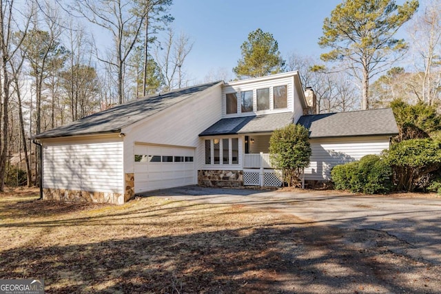 view of front property with a porch and a garage