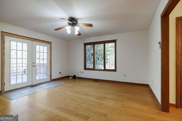 spare room with ceiling fan, light hardwood / wood-style flooring, french doors, and a wealth of natural light