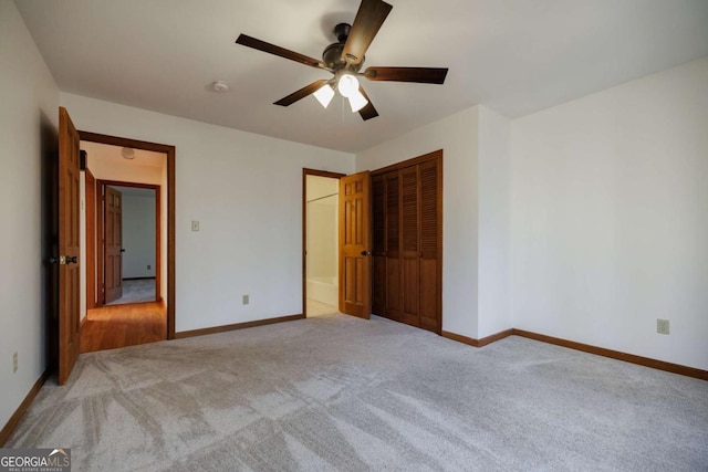 unfurnished bedroom featuring ceiling fan, light colored carpet, and a closet