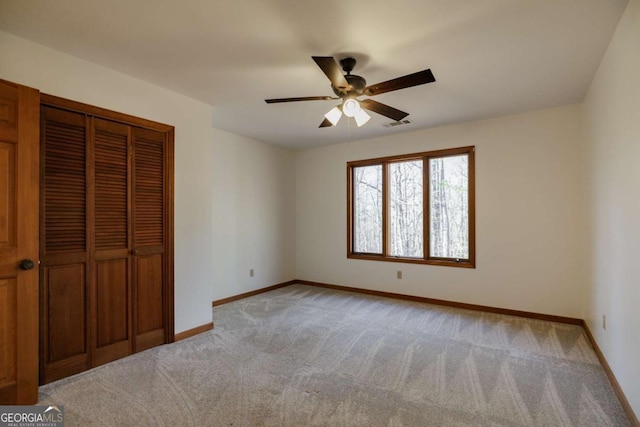 unfurnished bedroom with ceiling fan, light colored carpet, and a closet