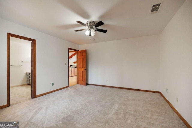 spare room featuring light colored carpet and ceiling fan