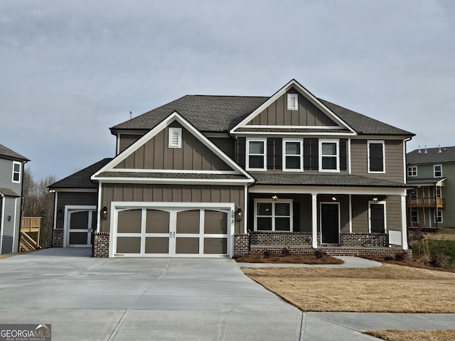 craftsman-style house featuring concrete driveway, an attached garage, covered porch, and board and batten siding