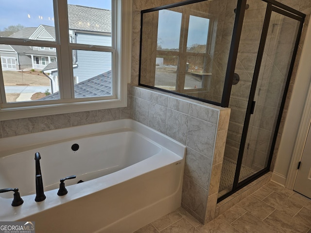 bathroom featuring a stall shower and a garden tub