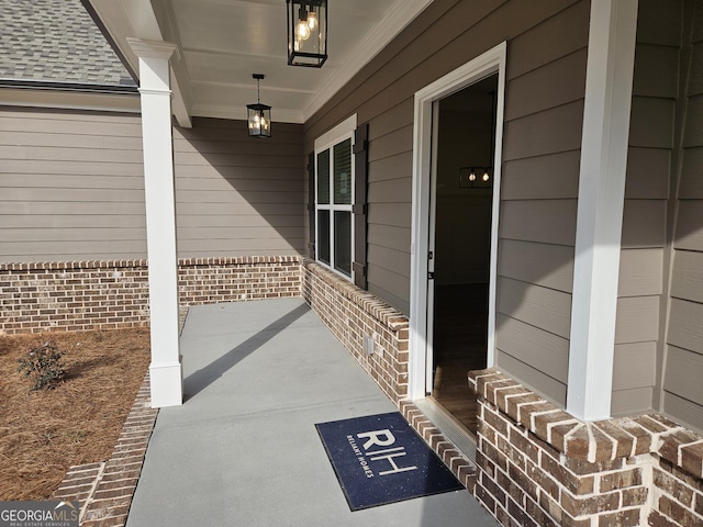 entrance to property featuring covered porch and a shingled roof