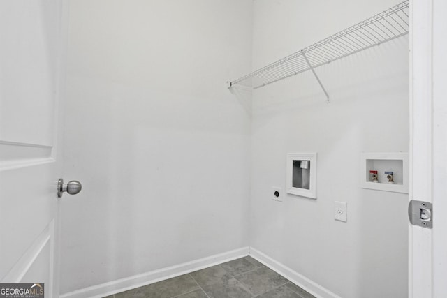 clothes washing area featuring hookup for a washing machine, electric dryer hookup, and dark tile patterned floors