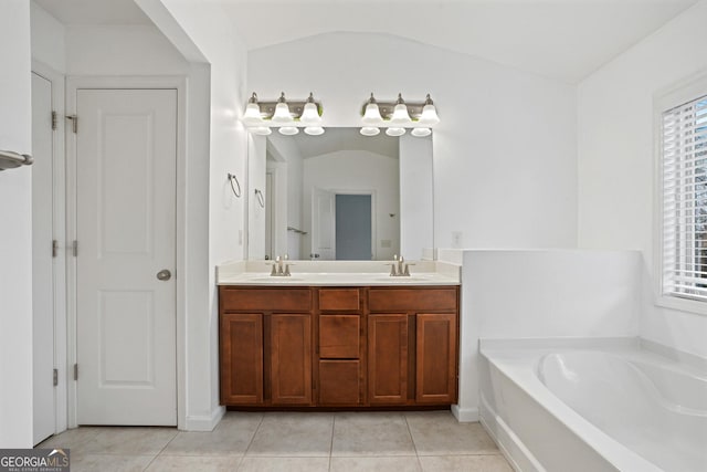 bathroom with vanity, lofted ceiling, a bath, and tile patterned floors