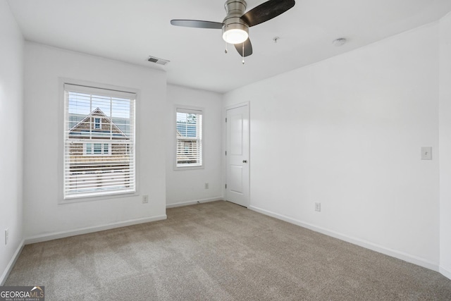 unfurnished room with ceiling fan and light carpet