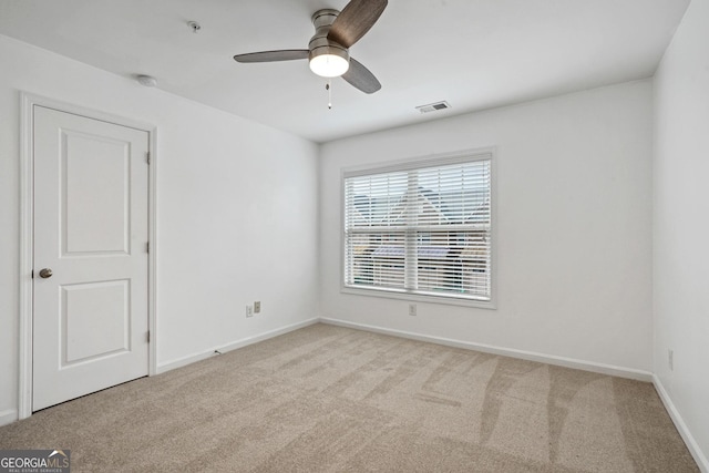 empty room featuring light carpet and ceiling fan