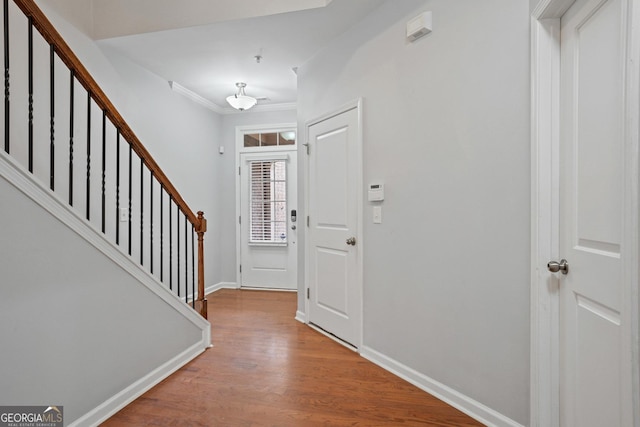 foyer featuring wood-type flooring and ornamental molding