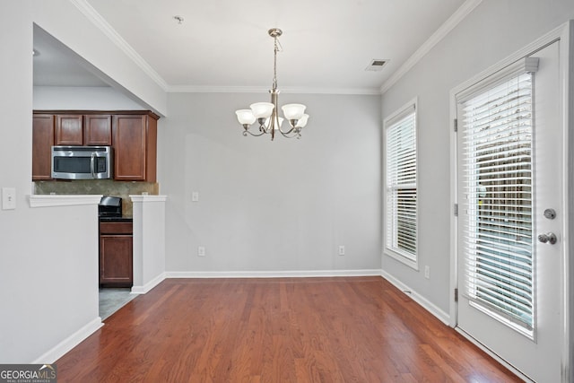 unfurnished dining area featuring pendant lighting, a notable chandelier, dark hardwood / wood-style flooring, and ornamental molding