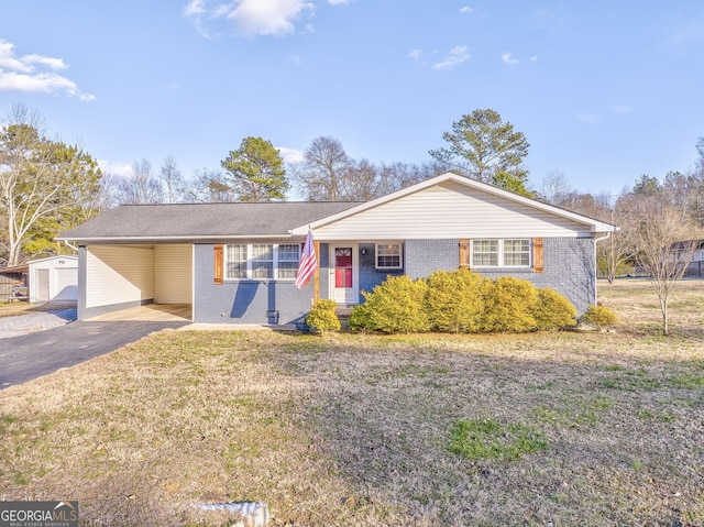 single story home with a front yard, an outbuilding, and a carport