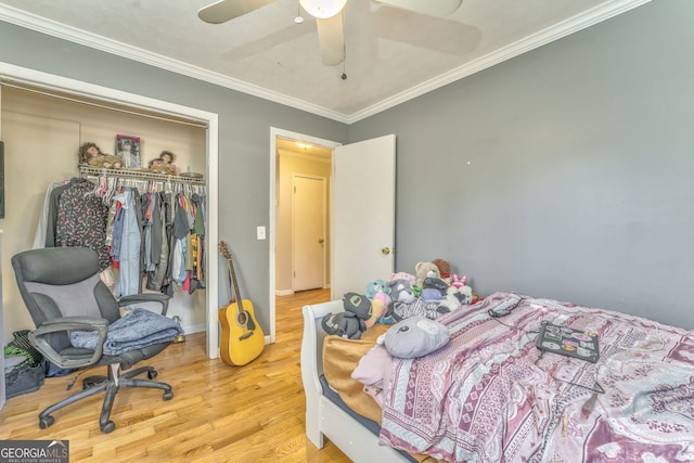 bedroom with ceiling fan, a closet, crown molding, and hardwood / wood-style flooring