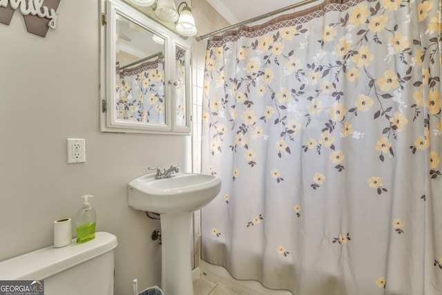 bathroom featuring toilet, a shower with shower curtain, and sink