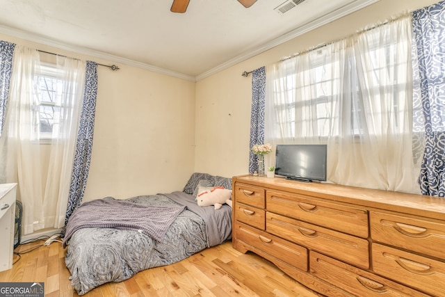 bedroom featuring ornamental molding, ceiling fan, light hardwood / wood-style flooring, and multiple windows