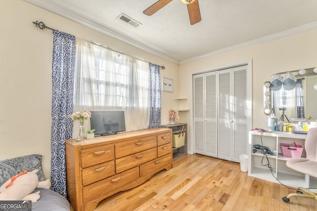 bedroom with a closet, ceiling fan, ornamental molding, and light hardwood / wood-style flooring