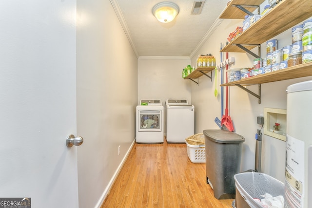 laundry area with gas water heater, ornamental molding, light hardwood / wood-style floors, and independent washer and dryer