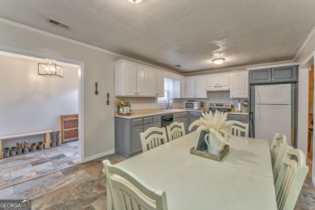 dining area featuring a textured ceiling, crown molding, and sink