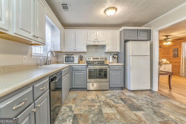 kitchen featuring white appliances, ceiling fan, white cabinetry, and crown molding