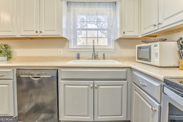 kitchen with dishwashing machine, white cabinetry, electric range, and sink