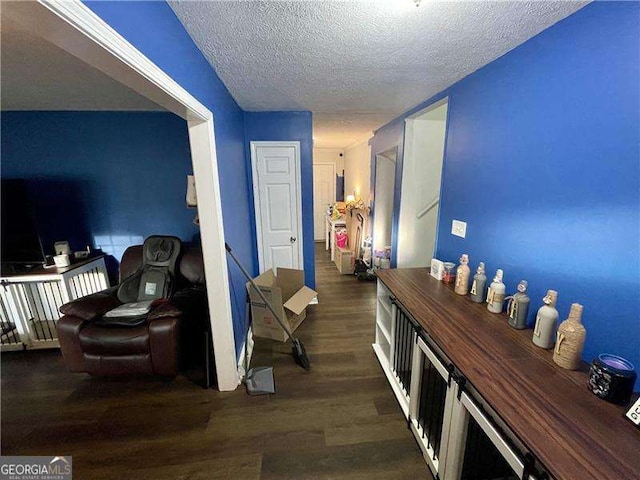 hall with a textured ceiling and dark hardwood / wood-style floors