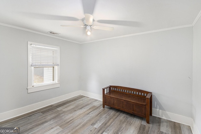 unfurnished room featuring ornamental molding, ceiling fan, and light wood-type flooring