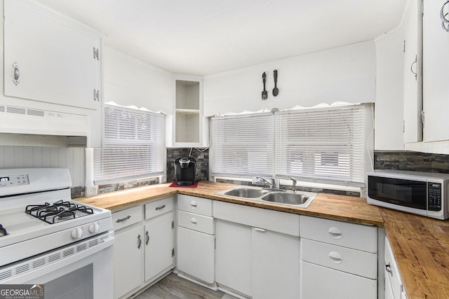 kitchen with sink, tasteful backsplash, white cabinets, wood counters, and white gas range