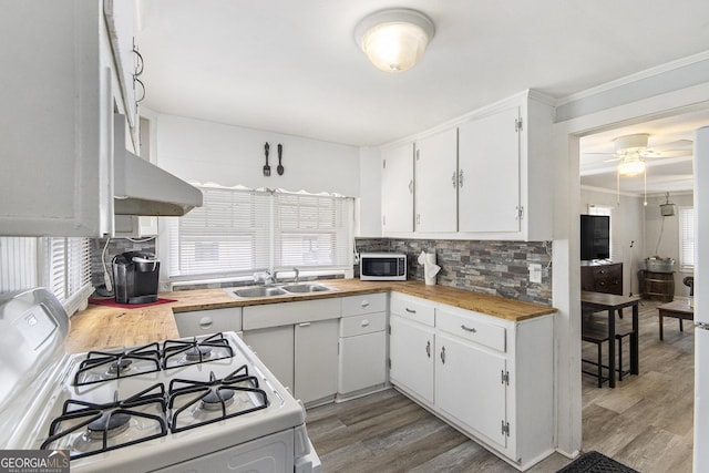 kitchen featuring sink, hardwood / wood-style flooring, white range with gas stovetop, backsplash, and white cabinets